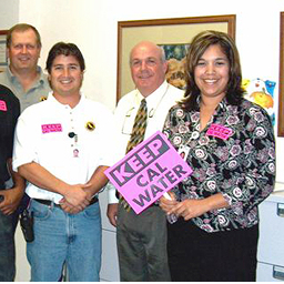 Employees after council meeting hold signs that say